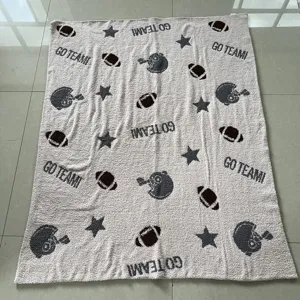 Vista dettagliata di una comoda coperta in maglia con motivi di football e caschi per gli sportivi.