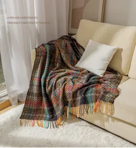 Detailed view of bohemian chenille chevron throw blanket with fringe, cozy sofa decor.