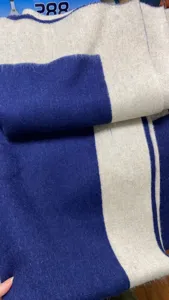 Detailaufnahme der weichen Woll Kaschmir Decke mit stilvollen blauen und beigen Streifen.