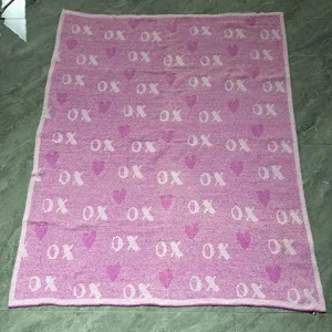 Valentine's Day pink knit blanket featuring cozy XO and heart pattern, soft plush throw.