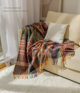 Cozy detail view of a bohemian chevron chenille throw blanket with fringe on sofa.