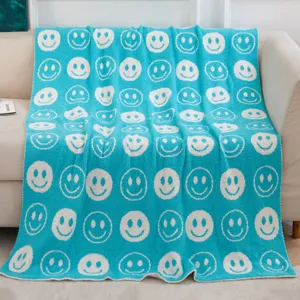 Nahaufnahme einer weichen Jacquard Kuscheldecke mit niedlichem Smiley Gesicht Muster.