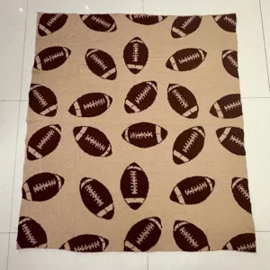 Coperta in morbida maglia marrone e beige con motivo a tema football americano per divano