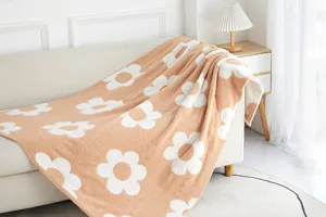 Close-up detail of cozy knit microfiber throw blanket with cute white floral pattern.
