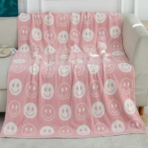 Gemütliche rosa flauschige Kuscheldecke mit weißem Smiley-Gesicht für das Wohnsofa.