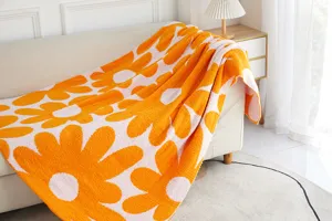 Cozy ultra-soft microfiber knit blanket featuring vibrant orange and white daisy patterns.