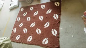 Morbida coperta in pile lavorata a maglia marrone con motivo da football per divano.