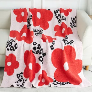 Cozy pink knit blanket featuring bold red floral and chic leopard print patterns for home.