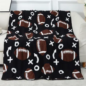 Dettaglio coperta soffice fantasia football, plaid lavorato a maglia jacquard per divano.