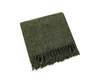 Dark green knitted throw blanket detail closeup with decorative fringe tassels for cozy living room.