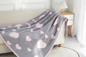 Cozy grey fleece blanket with pink hearts, soft textured throw for sofa living room detail.