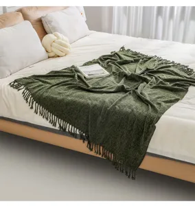 Dark green fringed knitted throw blanket for cozy sofa and warm bedroom decor use.