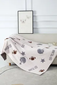 Comoda coperta in morbido filato di piuma con motivi jacquard a tema football.