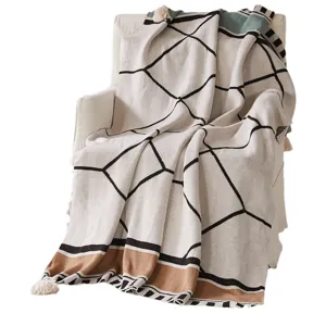 Bohemian knitted throw blanket with geometric pattern and tassels for sofa and camping use.