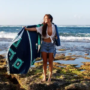 Detailed view of a woven Mexican blanket featuring Aztec geometric patterns in deep blue and turquoise.