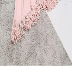 Rosa Stricktagesdecke mit Fransen, weiche Sofadecke als stilvolles Wohnaccessoire.