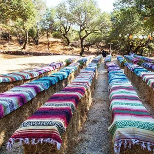 Detailed view of traditional Mexican serape blankets used outdoors, colorful woven design.