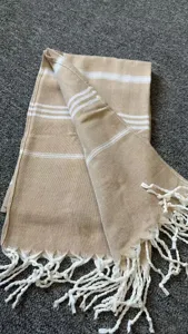 Turkish style woven beach towel with white stripes and fringe, khaki blanket detail view.