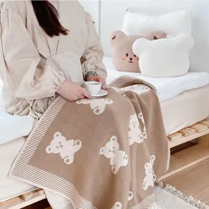 Détail de couverture en coton tricoté douillet avec joli motif d'ours de dessin animé.