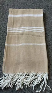Detailed view of woven throw blanket featuring white horizontal stripes and fringe.