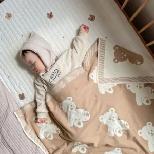 Couverture de bébé en tricot de coton doux avec motif d'ours et haut à capuche tons neutres.