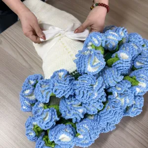 Handmade crochet blue flower bouquet blanket detail view showing ribbon tying on soft yarn material.
