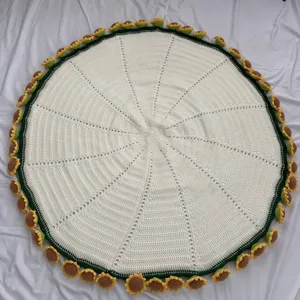 Detailed view of handmade crochet sunflower blanket, round white knit mat edge floral decor.