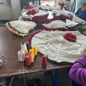 Handmade crochet rose blanket finished product, white base with red flower details for home decor.