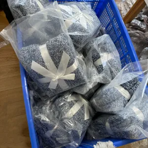 Detailed shot of thickened knitted blanket in blue and white, tied with white ribbon, in storage.