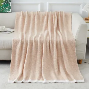 Cozy soft fuzzy knitted blanket draped on sofa detail view, warm home decor textile.