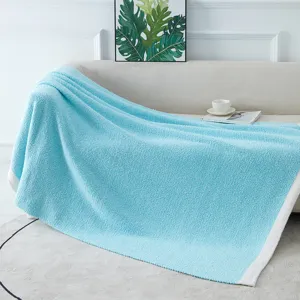 Cozy light blue soft fleece blanket draped on a clean sofa for home decor detail shot.