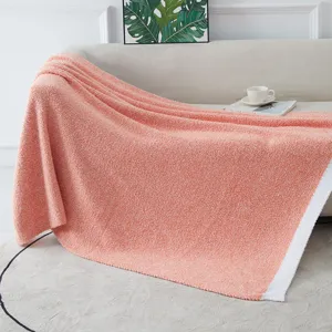 Cozy coral pink knitted plush blanket detail, soft warm home decor throw for sofa and living room.