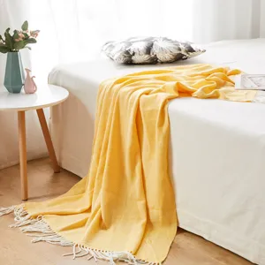 Yellow herringbone woven throw blanket with fringe for cozy bedroom sofa and bed decor.
