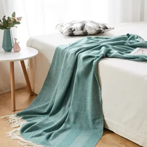 Cozy green herringbone knit throw blanket with fringe tassels for comfortable sofa bed decor