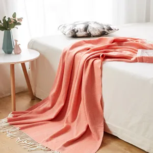 Coral herringbone knit throw blanket with fringe, cozy woven decorative bed blanket.
