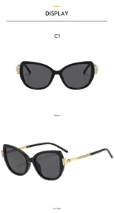 Detailansicht modischer Strass-Katzenaugen-Sonnenbrille, schwarzer Rahmen und Goldbügel.