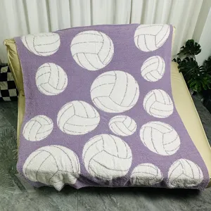 Detailed view of the purple knitted fleece throw blanket featuring white volleyball patterns.