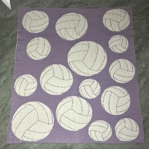 Detailed view of the purple knitted fleece blanket featuring a cute white volleyball pattern.