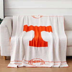 Vista dettagliata di coperta in filato di piuma bianca lavorata a maglia con logo.