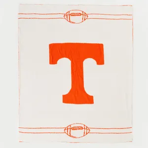 Coperta in jacquard lavorata a maglia con logo T arancione e motivo di calcio per la casa.