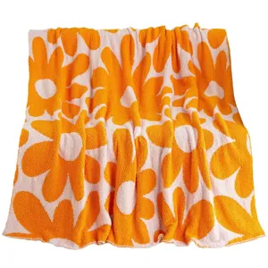 Fluffy microfiber knit blanket with vibrant orange and pink retro floral pattern for cozy home decor.