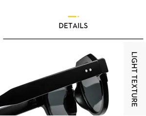 Sunglasses detail view featuring sleek black acetate frame and temple metal rivet accents.