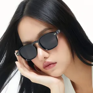 Primer plano detallado de gafas de sol elegantes con montura negra y diseño muy moderno.