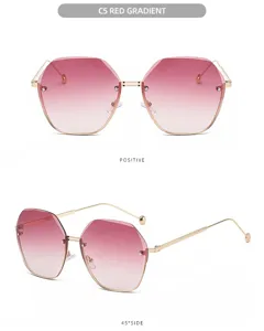 Vista detallada de gafas de sol poligonal sin montura para mujer con lentes degradadas rojas.
