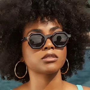 Detailansicht der stilvollen polygonen Sonnenbrille mit dickem Acetatrahmen und dunklen Gläsern.