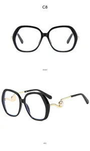 Detail view of stylish black frame glasses with pearl decor, showing side and front angles.