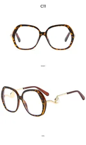 Close-up of large tortoise shell glasses frame with elegant pearl metal temples detail.