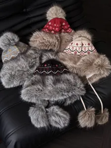 Winter ethnic knit trapper hat detailed view, thick plush earflap warm furry pompom design.