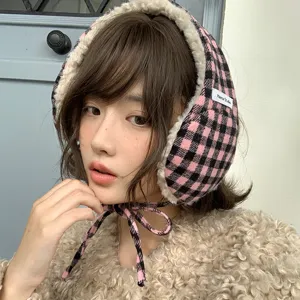 Vue detaillee de cache-oreilles a carreaux roses avec doublure en peluche douce et liens.