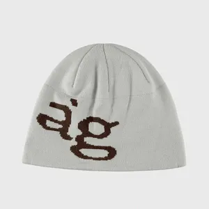 Detailed view of grey knit beanie hat featuring brown letter pattern for casual streetwear.